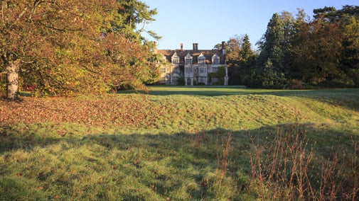View of the gardens and house in autumn at Anglesey Abbey, Cambridgeshire
